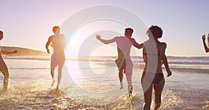 Beach, sunset and people playing in ocean together for fun on travel, vacation or holiday in summer. Splash, wave and