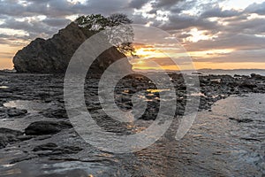 beach sunset, rock on the horizon