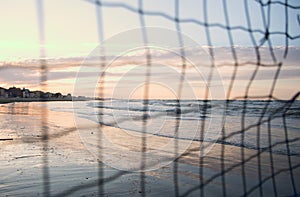 Beach at sunset seen through the net