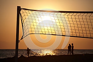 Beach sunset with silhouette of beachball net