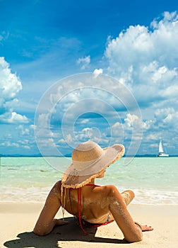 Beach suntan vacation bikini woman lying down tanning under tropical sun in Caribbean.