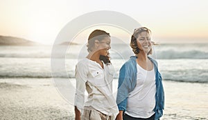 The beach teaches you something about communication. Shot of a loving couple walking hand in hand on the beach.