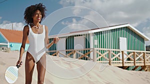 Beach tennis girl playing practicing on sunny day. Slim attractive player enjoy