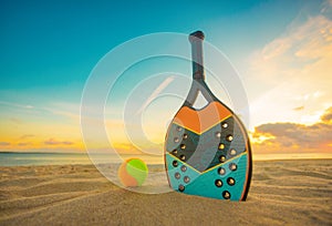 Beach tennis racket. Background with copy space. Sport court at the beach and ball.