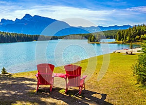 On the beach there are red chaise lounges