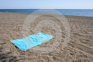 Beach towel on the black sand beach of Perissa
