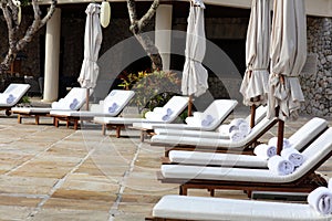 Beach towels at tropical resort and seats for laying in the sun at luxury hotel