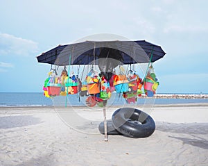 beach toys hanging under umbrella for selling at seaside