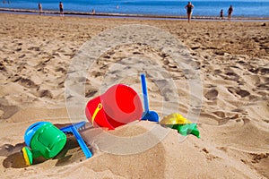 Beach toys in sand on sea shore