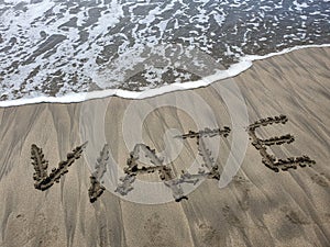 sand with hand drawing letters for beach travel and tropical tourism photo