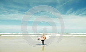 Beach, travel and woman with surfboard on blue sky with sea or ocean for sports, fitness and hobby. Earth, nature and