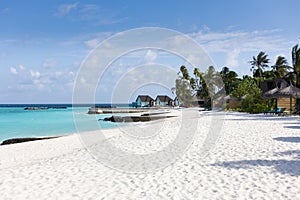 Beach of a tropical island with white sand and turquoise water on the maledives