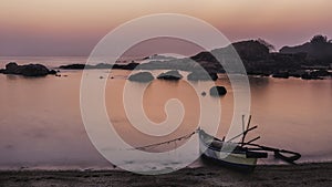 Beach tropical paradise at pink sunset with a boat