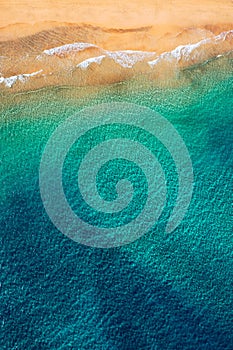 Beach with turquoise water on Fuerteventura island, Spain, Canary islands. Aerial view of sand beach, ocean texture background,