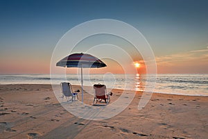 Beach umbrella and chairs on the beach at Sunrise
