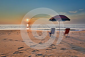 Beach umbrella and chairs on the beach at Sunrise