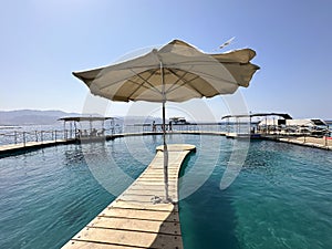 Beach umbrella on the footbridge in the sea