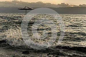 Beach umbrella in the Lake Ohrid at stormy weather sunset