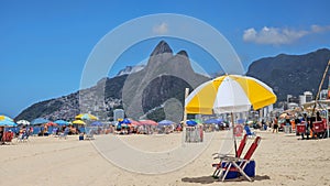 Beach umbrella ready for beachgoer on Ipanema beach Rio de Janeiro with Dois Irmaos in the background