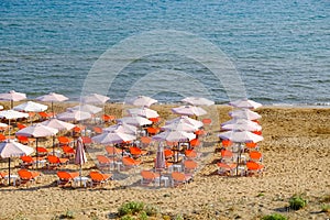 Beach umbrella and sunbeds on the sandy beach in Greece