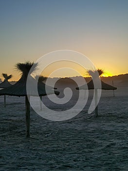 Beach umbrellas against the setting sun of the Atlantic coast of Argentina