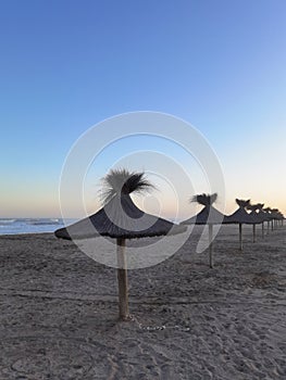 Beach umbrellas against the setting sun of the Atlantic coast of Argentina