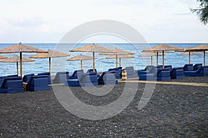 Beach umbrellas and blue sun beds on the sand