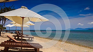 beach umbrellas chairs on gold sand against azure sea