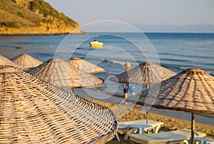 Beach umbrellas and chaise lounges with sea and sky in the background