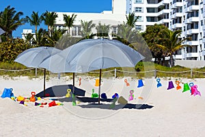 Beach umbrellas and children's toys on the sand.