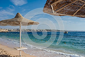 beach umbrellas and loungers on a beach at an idyllic tropical resort for a summer vacation