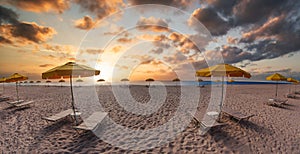 Beach with umbrellas and sun beds at sunset