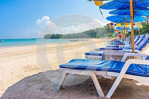 Beach umbrellas and sunbathe seats on Phuket sand beach