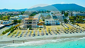 beach with umbrellas and sunbeds resort Rhodes, Greece, panoramic drone views of the black sea, coast and the island