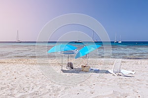 Beach umbrellas on white sand under the hot Ibiza sun. Balearic Islands. Spain