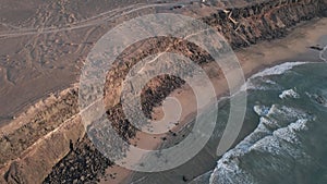 A beach under a cliff aerial view