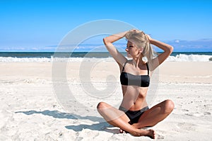 Beach vacation. Beautiful tanned woman in bikini relaxing on the tropical beach