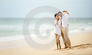 Beach vacation couple taking selfie photograph using smartphone