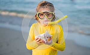 Beach vacation. Fun kid wearing a snorkel scuba mask found a coral or shell in ocean water. Summer Kids Snorkeling