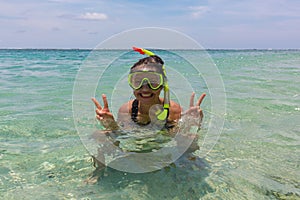 Beach vacation fun woman wearing a snorkel scuba mask making a goofy face while swimming in ocean water. Closeup