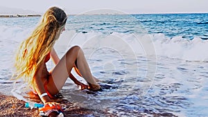 Beach vacation of girl sitting on sand beach in sea