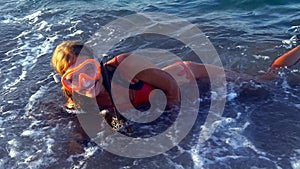 Beach vacation of girl sunburning by sea foam wave