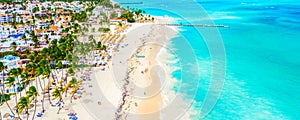 Beach vacation and travel background. Aerial drone view of beautiful atlantic tropical beach with straw umbrellas, palms and boats