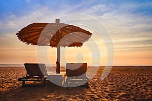 Beach vacation, two sunbeds and parasol, holidays travel background, summer