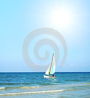 Beach view with big sun and sail