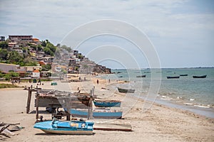 Beach view with fishermen and traditional Angolan boats, in Luanda beach, ghetto as background