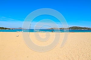 Beach volley net and surfers in Porto Pollo beach