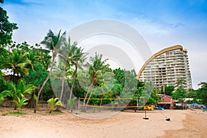 Beach with volleyball net and green palm trees