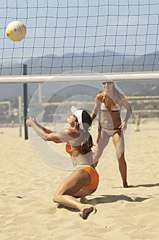 Beach volleyball player diving for volleyball