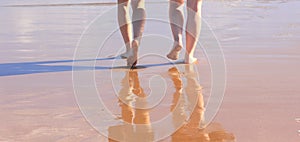 Beach walk barefoot in wet sand, two woman in holidays